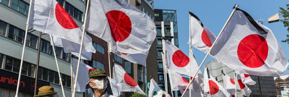 Demonstrators hold Japanese national flags as they march during a protest in support of the Yasukuni Shrine on August 15, 2020 in Tokyo, Japan. (Image by Yuichi Yamazaki/Getty Images News/Getty Images)