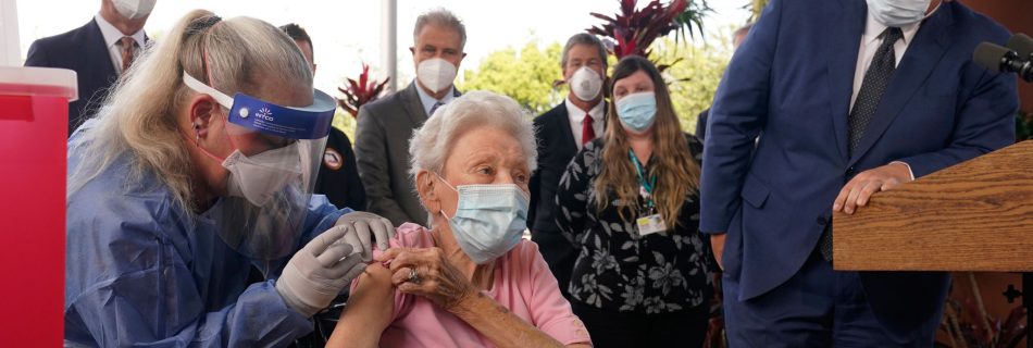 Florida Gov. Ron DeSantis watches as nurse Christine Philips, left, administers the Pfizer-BioNTech vaccine for COVID-19 to Vera Leip, 88, a resident of John Knox Village, Wednesday, Dec. 16, 2020, in Pompano Beach, Fla. Nursing home residents and health care workers in Florida began receiving the vaccine this week. (AP Photo/Marta Lavandier)